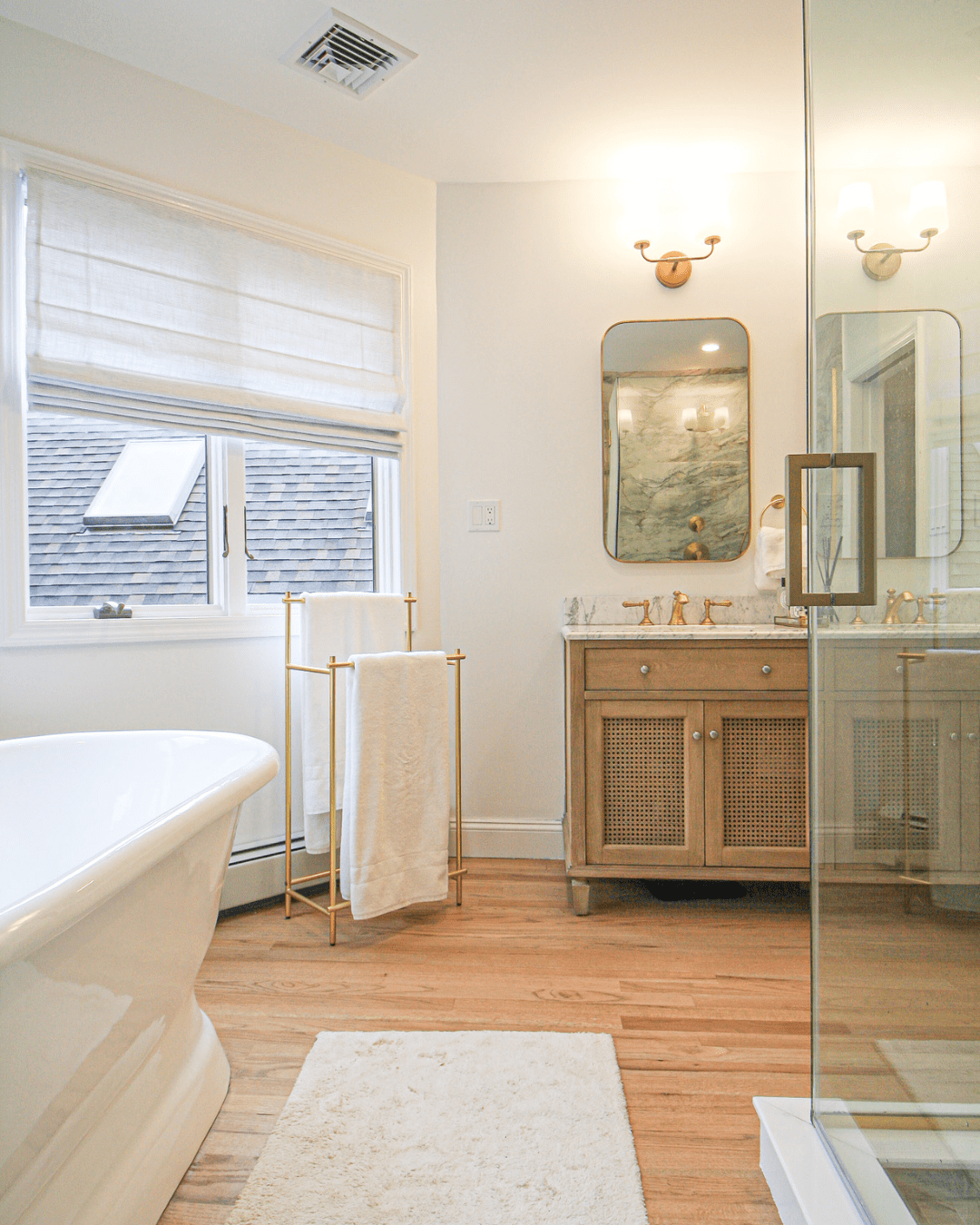 Continuous wood flooring for a cohesive bath design in a master bath renovation.